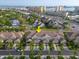 Aerial view of townhomes featuring beige exteriors, lawns, and proximity to coastal areas at 11260 Kapok Grand Cir, Madeira Beach, FL 33708