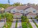 Aerial view of the townhomes featuring garages, beige exteriors and well maintained lawns at 11260 Kapok Grand Cir, Madeira Beach, FL 33708