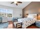 Bedroom with ceiling fan, hardwood floors, and a large window plus neutral paint at 11260 Kapok Grand Cir, Madeira Beach, FL 33708