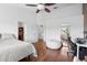 Bedroom featuring hardwood floors, ceiling fan, and walk-in closet, plus neutral paint at 11260 Kapok Grand Cir, Madeira Beach, FL 33708