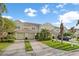 Beige townhome exteriors with two-car garages and well-manicured lawns are featured in this shot at 11260 Kapok Grand Cir, Madeira Beach, FL 33708