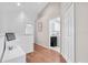 Upstairs hallway featuring white walls, wood flooring, a half-wall and views of an upstairs laundry room at 11260 Kapok Grand Cir, Madeira Beach, FL 33708