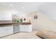 Well-lit kitchen featuring white cabinets and stainless steel appliances at 11260 Kapok Grand Cir, Madeira Beach, FL 33708