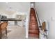 Staircase with adjacent, updated kitchen featuring white cabinets and stainless steel appliances at 11260 Kapok Grand Cir, Madeira Beach, FL 33708