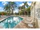 Community pool with lounge chairs, lush landscaping, and decorative wall art at 11260 Kapok Grand Cir, Madeira Beach, FL 33708