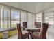 Bright sunroom features a glass-top table with wicker chairs and large windows with plenty of natural light at 11487 80Th Ave, Seminole, FL 33772
