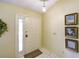 Bright foyer features a white door, tile flooring, and decorative wall art at 12024 Stone Crossing Cir, Tampa, FL 33635
