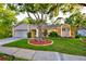 Charming single-story home featuring a well-manicured lawn and a mature shade tree enhancing curb appeal at 12024 Stone Crossing Cir, Tampa, FL 33635