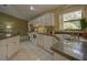 Bright kitchen featuring granite countertops, white cabinets, and a built-in desk area at 12024 Stone Crossing Cir, Tampa, FL 33635