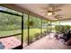 Serene screened porch with comfortable seating, overlooking a lush backyard with greenery at 12024 Stone Crossing Cir, Tampa, FL 33635