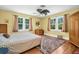 Bright bedroom featuring hardwood floors, two windows, a ceiling fan and a cozy rug at 1226 Serpentine S Dr, St Petersburg, FL 33705