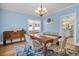 Traditional dining room with hardwood floors and chandelier, featuring a wooden table and colorful area rug at 1226 Serpentine S Dr, St Petersburg, FL 33705