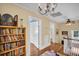 View of the second story hallway with book shelves and a chandelier lighting the upstairs space at 1226 Serpentine S Dr, St Petersburg, FL 33705