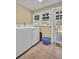 Laundry room featuring a washer, dryer, and tile flooring, next to the door to outside at 1226 Serpentine S Dr, St Petersburg, FL 33705