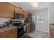 Well-lit kitchen featuring stainless steel appliances and wood cabinets at 12937 Trade Port Pl, Riverview, FL 33579