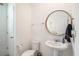 Powder room with a round mirror and modern fixtures and a pedestal sink at 13802 Kinsale St, Riverview, FL 33579