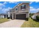 Two-story home with a gray exterior, brick-paved driveway, two-car garage, and manicured front lawn at 13802 Kinsale St, Riverview, FL 33579
