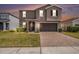Two-story home with well-maintained lawn and a brick driveway leading to a garage at 13802 Kinsale St, Riverview, FL 33579