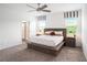 Spacious main bedroom featuring plush carpet, ceiling fan, and ensuite bathroom at 13802 Kinsale St, Riverview, FL 33579