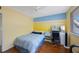 Bright bedroom with sunny yellow walls, blue accents, and modern furniture at 14649 Seminole Trl # 5, Seminole, FL 33776