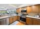 Kitchen boasts stainless appliances, wood cabinets, granite countertops, and access to living area at 14649 Seminole Trl # 5, Seminole, FL 33776