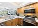 Bright kitchen features stainless appliances, granite countertops, wood cabinets, and view into living area at 14649 Seminole Trl # 5, Seminole, FL 33776