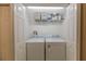 Laundry closet has white washer and dryer with storage shelf on top, enclosed by white bi-fold doors at 14649 Seminole Trl # 5, Seminole, FL 33776