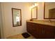 Bathroom featuring double sinks, wood cabinets, granite countertops, and a mirror at 1670 Palmwood Dr, Clearwater, FL 33756