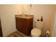 Close-up of a bathroom with a decorative sink, vanity, toilet, and neutral tiled floors at 1670 Palmwood Dr, Clearwater, FL 33756