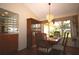 A dining room featuring a china cabinet, wood table, decorative lighting, and a large window at 1670 Palmwood Dr, Clearwater, FL 33756