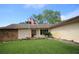 Inviting single-story home with a well-maintained front lawn, flowerbeds, and mature trees at 1670 Palmwood Dr, Clearwater, FL 33756