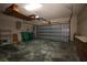 Large garage with overhead door, storage shelves, and parking space at 1670 Palmwood Dr, Clearwater, FL 33756