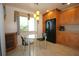 Eat-in kitchen features a glass table, black refrigerator, wood cabinets, and tile floors at 1670 Palmwood Dr, Clearwater, FL 33756