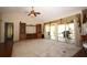 Spacious living room with vaulted ceilings, a built-in entertainment center, and sliding glass doors to a sunroom at 1670 Palmwood Dr, Clearwater, FL 33756