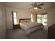 Bedroom with a ceiling fan, carpeted floors, a king bed, and a sliding glass door leading to the patio at 1670 Palmwood Dr, Clearwater, FL 33756