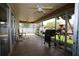 A screened patio with ceiling fans, tiled flooring, outdoor furniture, and tropical plants at 1670 Palmwood Dr, Clearwater, FL 33756