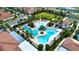 Aerial view of a community pool with palm trees, lounge chairs, and lush landscaping at 16913 Clear Cork Dr, Wimauma, FL 33598