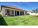 A spacious backyard with a well-maintained lawn, screened-in lanai, and manicured landscaping at 16913 Clear Cork Dr, Wimauma, FL 33598