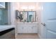 Elegant bathroom with double vanity, framed mirrors, and modern lighting fixtures at 16913 Clear Cork Dr, Wimauma, FL 33598