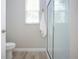 Clean bathroom with a glass-enclosed shower, toilet, and a bright window at 16913 Clear Cork Dr, Wimauma, FL 33598