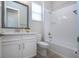 Bright bathroom featuring a large vanity, mirror, toilet, and shower/tub combo with white tile surround at 16913 Clear Cork Dr, Wimauma, FL 33598