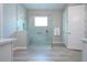 Bright bathroom featuring a glass enclosed shower with grey tiling and wood-look flooring at 16913 Clear Cork Dr, Wimauma, FL 33598