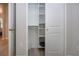 A clean closet with multiple shelves and room to hang clothing, plus wooden-style tile and base molding at 16913 Clear Cork Dr, Wimauma, FL 33598