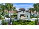 The clubhouse features a welcoming entrance with palm trees, colorful foliage, and a porte cochere at 16913 Clear Cork Dr, Wimauma, FL 33598