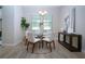 Bright dining room with a glass-top table, white chairs, modern lighting, and neutral decor at 16913 Clear Cork Dr, Wimauma, FL 33598