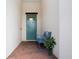 Cozy entryway with a blue door, brick floor, and a charming bench with decorative accents at 16913 Clear Cork Dr, Wimauma, FL 33598