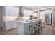 Modern white kitchen with stainless steel appliances, island with seating, and elegant countertops at 16913 Clear Cork Dr, Wimauma, FL 33598