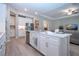 Island kitchen boasts a stainless steel dishwasher, and white countertops and cabinetry at 16913 Clear Cork Dr, Wimauma, FL 33598