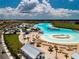 Aerial view of a lagoon, featuring white sand beaches, clear water, and various amenities at 16913 Clear Cork Dr, Wimauma, FL 33598