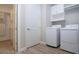 Bright laundry room with wood-look tile flooring, modern appliances, and built-in storage at 16913 Clear Cork Dr, Wimauma, FL 33598